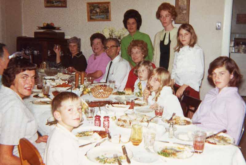 Vintage 1960's Family Gathers At Thanksgiving Dinner Table Happy Reunion Children Parents Grandparents Spend Time Together