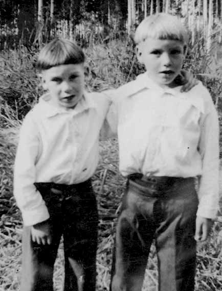Two Young Brothers Arms Around Each Other Wearing Shirts, Pants And Bowl Hair Cuts Circa 1935
