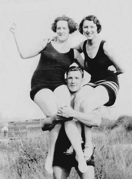 Early 1920's Strong Man Balancing Woman On Each Shoulder Wearing Vintage Bathing Suits At Crescent Beach