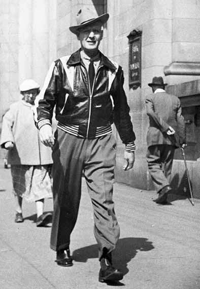 Male Walking On Downtown Vancouver City Sidewalk Wearing Hat Leather Jacket Shirt Tie Boots 1950's Atmosphere