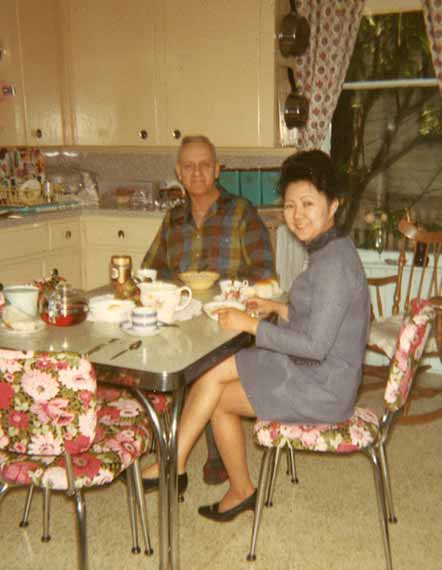 1960's Kitchen Older Caucasian Man Eating Lunch With Asian Woman At Table Happy Smiling 60's Decor