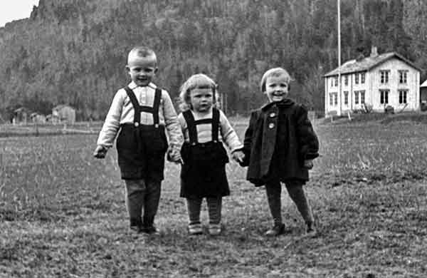 1943 Three Young Children Happily Hold Hands Together On Family Farm Field In Europe Wearing Lederhosen