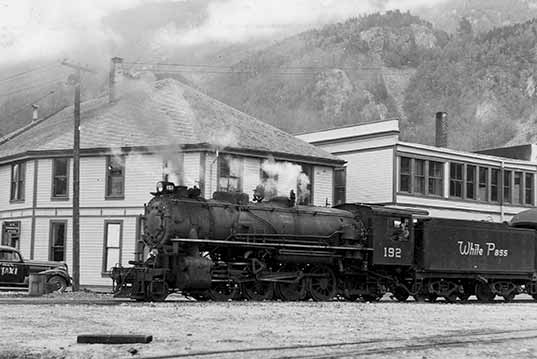White Pass Yukon Steam Locomotive #192 WP&YR Idling In Skagway Alaska Beside US Immigration Office 1949