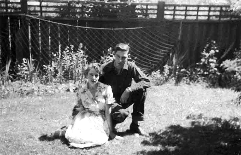 Late 1940's Teenage Male Kneels Next To Happy Loving Mother Sitting On Lawn Backyard Of House